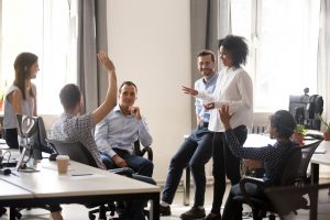 liderança inclusiva Diverse team in coworking space voting some colleagues agree raises hands. Positive black leader woman with creative group of businesspeople discussing sharing ideas together in office at meeting
