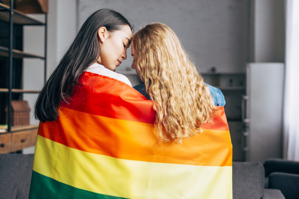 Duas mulheres jovens com a bandeira LGBT