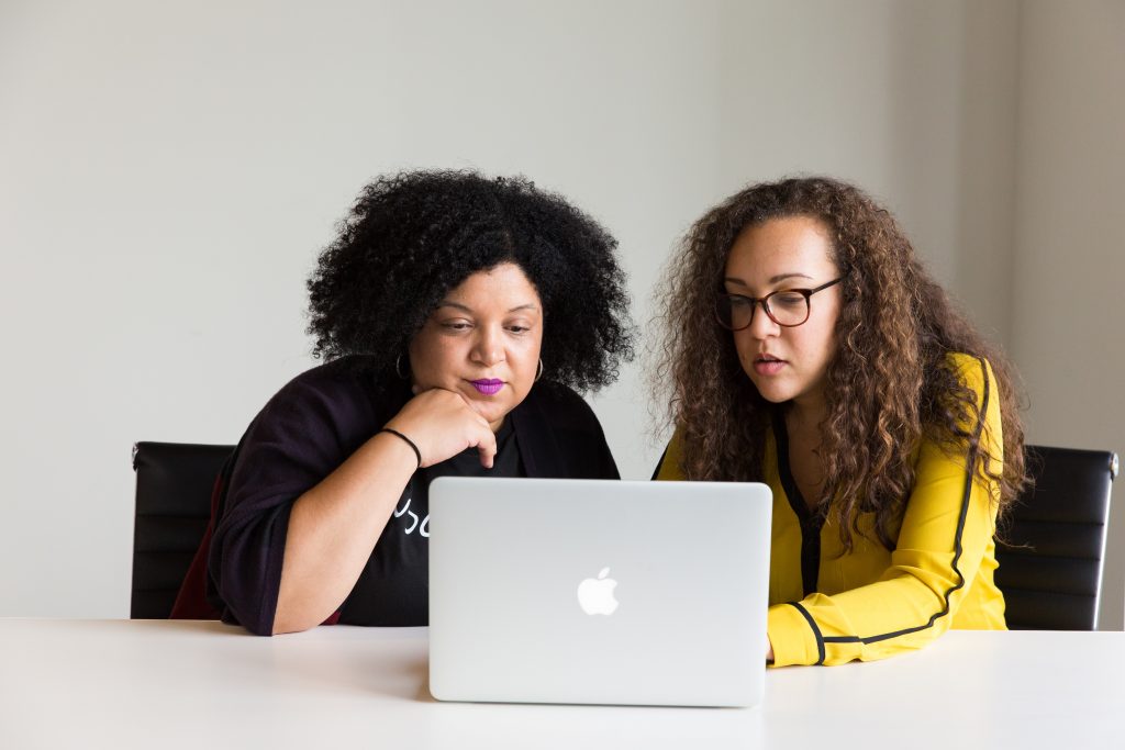 Foto com duas mulheres trabalhando em frente a um computador